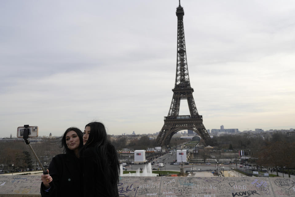 Turistas se toman una selfie frente a la Torre Eiffel, el miércoles 27 de diciembre de 2023, en París. (AP Foto/Lewis Joly)