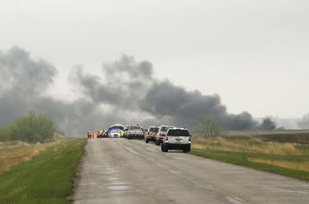 Smoke from the wreckage of several oil tanker cars that derailed in a field near the town of Heimdal, North Dakota May 6, 2015. REUTERS/Andrew Cullen