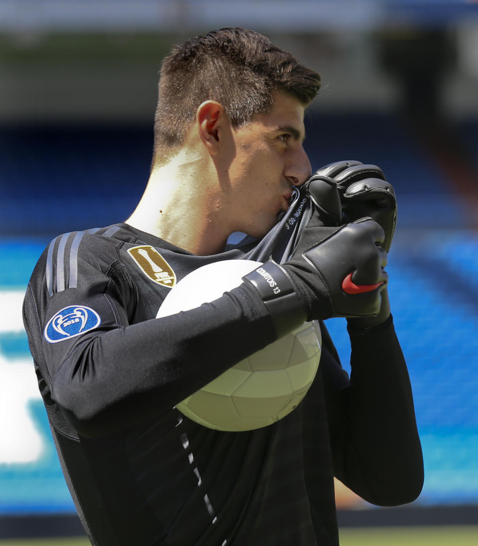 Belgian new Real Madrid soccer player Thibaut Courtois kisses his new shirt during his official presentation for Real Madrid at the Santiago Bernabeu stadium in Madrid, Thursday, Aug. 9, 2018. Chelsea has sold a player — goalkeeper Thibaut Courtois — to Real Madrid. The Belgian was replaced by Kepa Arrizabalaga after Chelsea met the goalkeeper's 80 million euro ($93 million) buyout clause from Athletic Bilbao on Wednesday. (AP Photo/Andrea Comas)