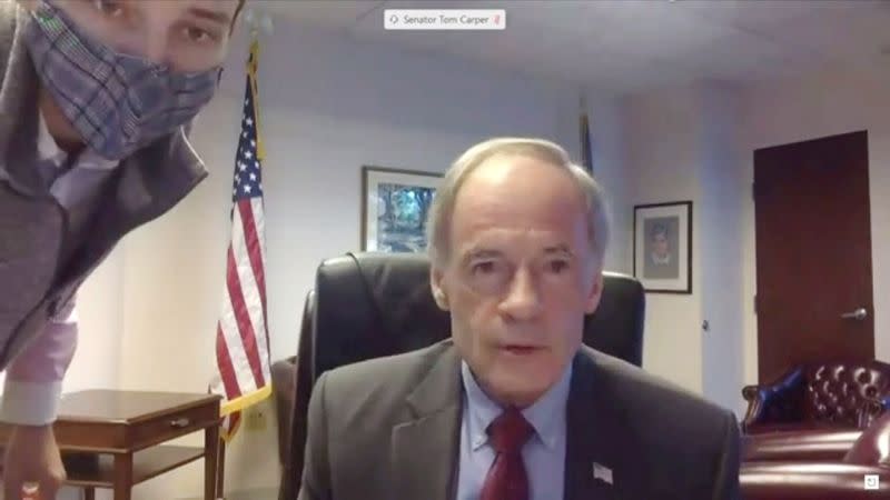 Aide assists Senator Carper with computer as U.S. Postmaster General Louis DeJoy testifies during virtual hearing of the U.S. Senate Homeland Security and Governmental Affairs Committee in Washington