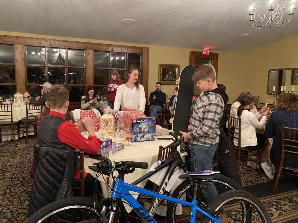 A young man checks out his new skateboard, a present from Olsen's Christmas Wish, at the organizations holiday party on Dec. 21.