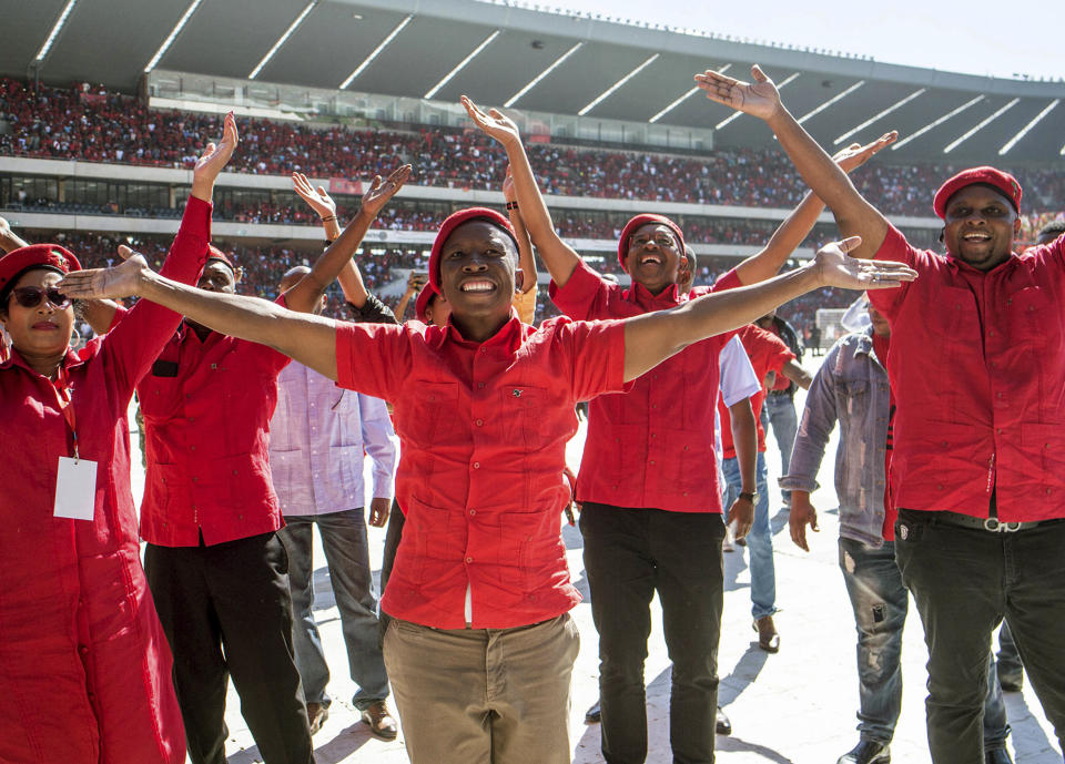 Leader of the Economic Freedom Fighters (EFF) party, Julius Malema, foreground, greets supporters at their final election rally at Orlando Stadium in Soweto, South Africa, Sunday, May 5, 2019. Campaign rallies for South Africa's upcoming election have reached a climax Sunday with mass rallies by the ruling party and one of its most potent challengers. (AP Photo/Mujahid Safodien)