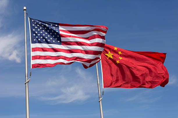 Symbolic of Sino-American relations, the flag of the United States of America and the flag of the Republic of China fly together on flag poles next to each other on a sunny, windy day.