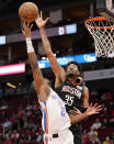 Oklahoma City Thunder guard Shai Gilgeous-Alexander (2) shoots as Houston Rockets center Christian Wood defends during the first half of an NBA basketball game, Monday, Nov. 29, 2021, in Houston. (AP Photo/Eric Christian Smith)