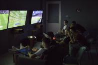 Unos jóvenes juegan a videojuegos en una sala de ocio de Ballsh. (Foto: Daniel Cole / AP).