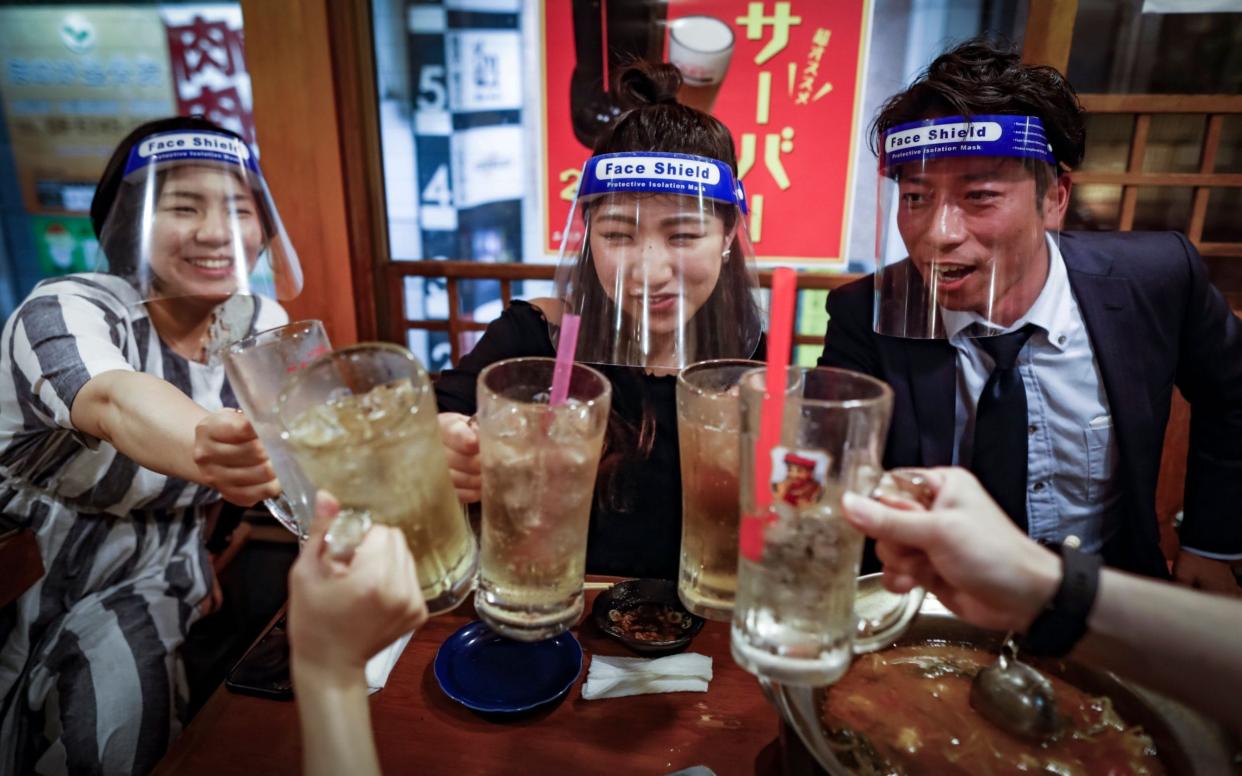 Customers wear plastic face shields while dining on a hot-pot dish at an izakaya in Osaka, Japan - DAI KUROKAWA/EPA-EFE/Shutterstock