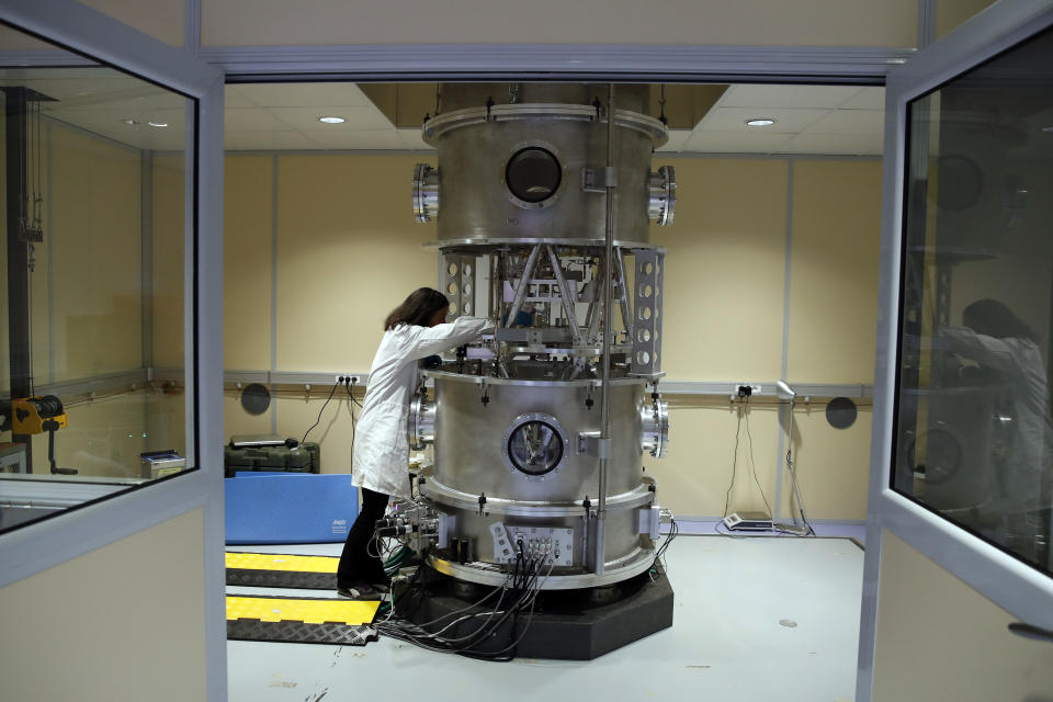 In this photo taken Wednesday, Oct. 17, 2018, Executive Secretary of the Consultative Committee for Mass and related quantities (CCM) Dr Hao Fang works at the International Bureau of Weights and Measures, in Sevres, near Paris. The golf ball-sized metal cylinder at the heart of the world's system for measuring mass is heading into retirement. Gathering this week in Versailles, west of Paris, governments on Friday Nov. 16, 2018, are expected to approve a plan to instead use a scientific formula to define the exact weight of a kilo. (AP Photo/Christophe Ena)