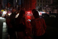 Pedestrians looks at their cellphones during a power outage in midtown Manhattan, Saturday, July 13, 2019, in New York. Authorities were scrambling to restore electricity to Manhattan following a power outage that knocked out Times Square's towering electronic screens and darkened marquees in the theater district and left businesses without electricity, elevators stuck and subway cars stalled. (AP Photo/Michael Owens)