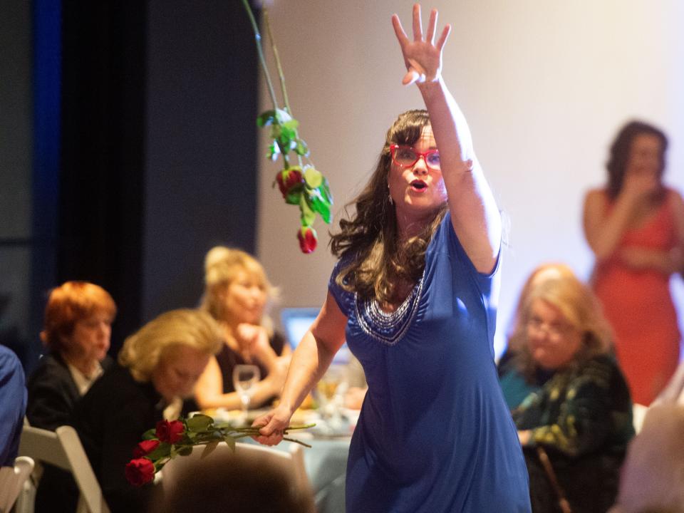 Opera singer Jacquie Brecheen tosses roses into the crowd as she performs at the benefit.
