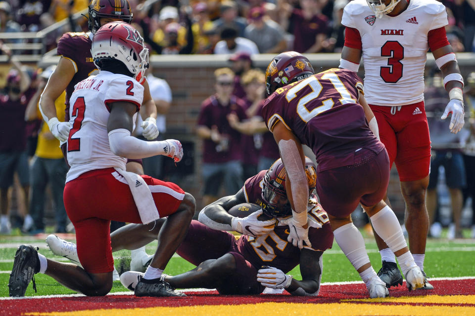 Minnesota wide receiver Dylan Wright, center, takes a 25-yard pass into the end zone for a touchdown before Miami-Ohio defensive back Cecil Singleton (2) can stop him as Minnesota running back Bryce Williams (21) runs up to celebrate during the second half of an NCAA college football game on Saturday, Sept. 11, 2021, in Minneapolis. Minnesota won 31-26. (AP Photo/Craig Lassig)