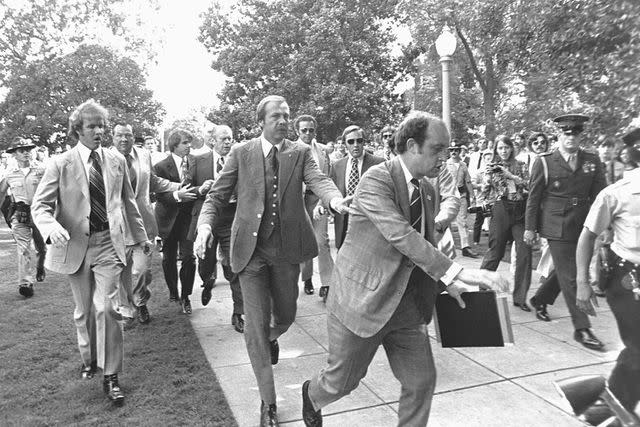 <p>Corbis via Getty</p> Police and Secret Service agents help President Gerald Ford (seen in the back of frame, left of center) get to safety after an attempted assassination on Sept. 5, 1975