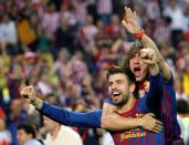 FILE PHOTO: Barcelona's Gerard Pique and fellow defender Carles Puyol celebrate after beating Athletic Bilbao 3-0 in the King's Cup final at the Vicente Calderon stadium in Madrid.