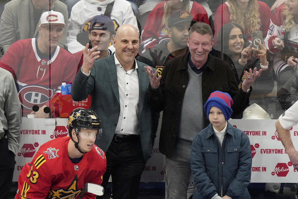 Team Hughes coaches Rick Tocchet, center left, and Wayne Gretzky, center right, react during the NHL All-Star Game 3-on-3 hockey tournament against Team Matthews in Toronto, Saturday, Feb. 3, 2024. (Nathan Denette/The Canadian Press via AP)