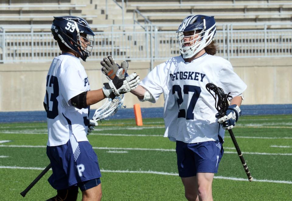 Petoskey's MJ Cesario (left) congratulates teammate Zach Jacobs after he scored during the second quarter.