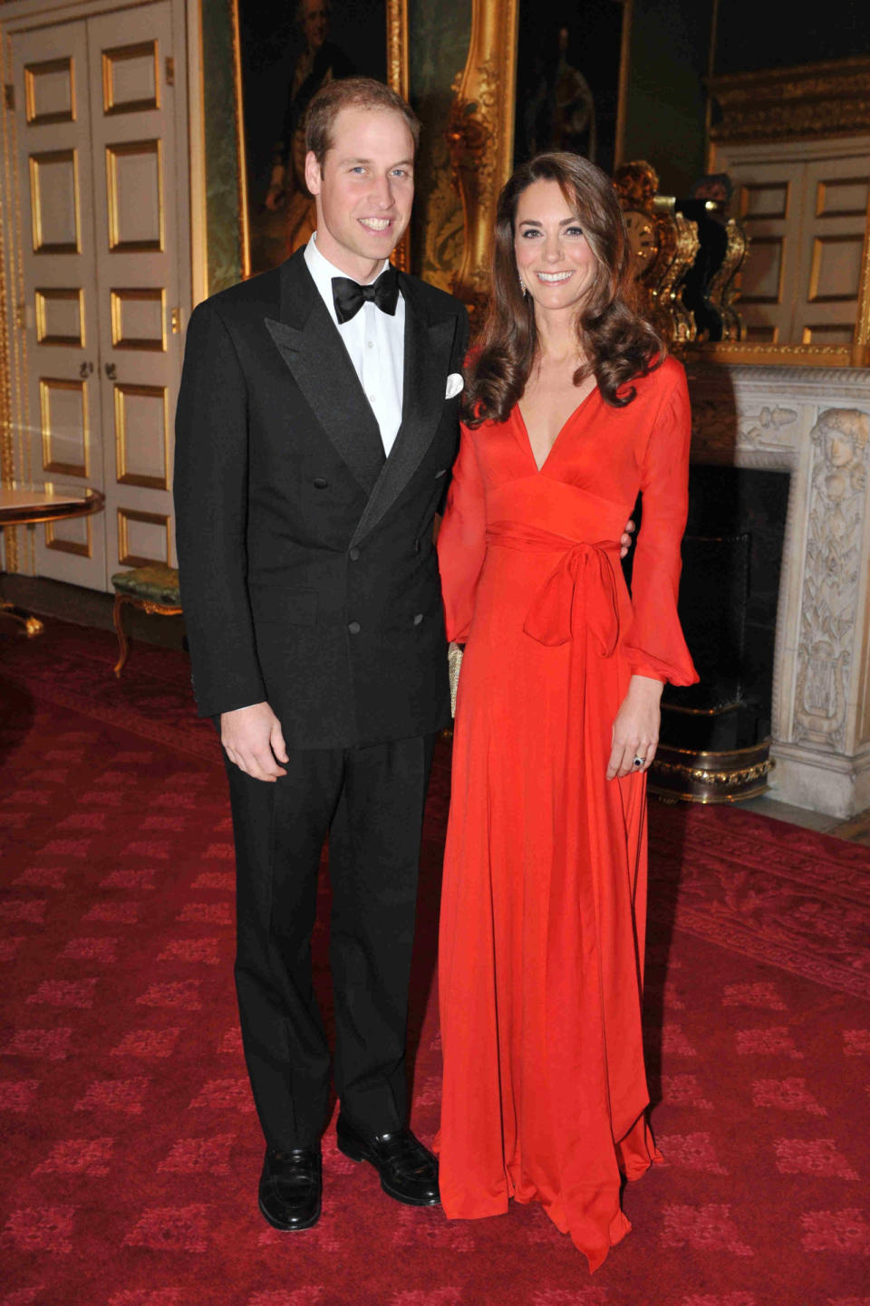 <p>Kate wore a vibrant red wrap dress by Beulah London for a fundraising gala, accessorising with a gold Wilbur and Gussie clutch.</p><p><i>[Photo: PA]</i></p>