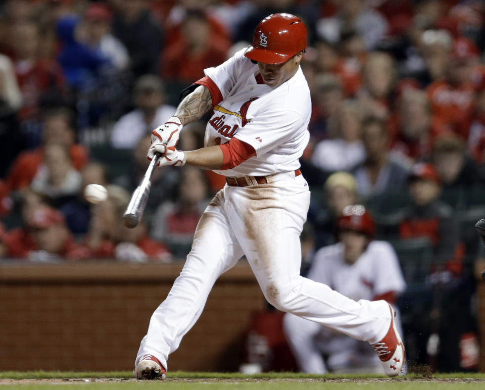 St. Louis Cardinals' Kolten Wong hits a two-run triple during the second inning of a baseball game against the Cincinnati Reds on Tuesday, April 8, 2014, in St. Louis. (AP Photo/Jeff Roberson)