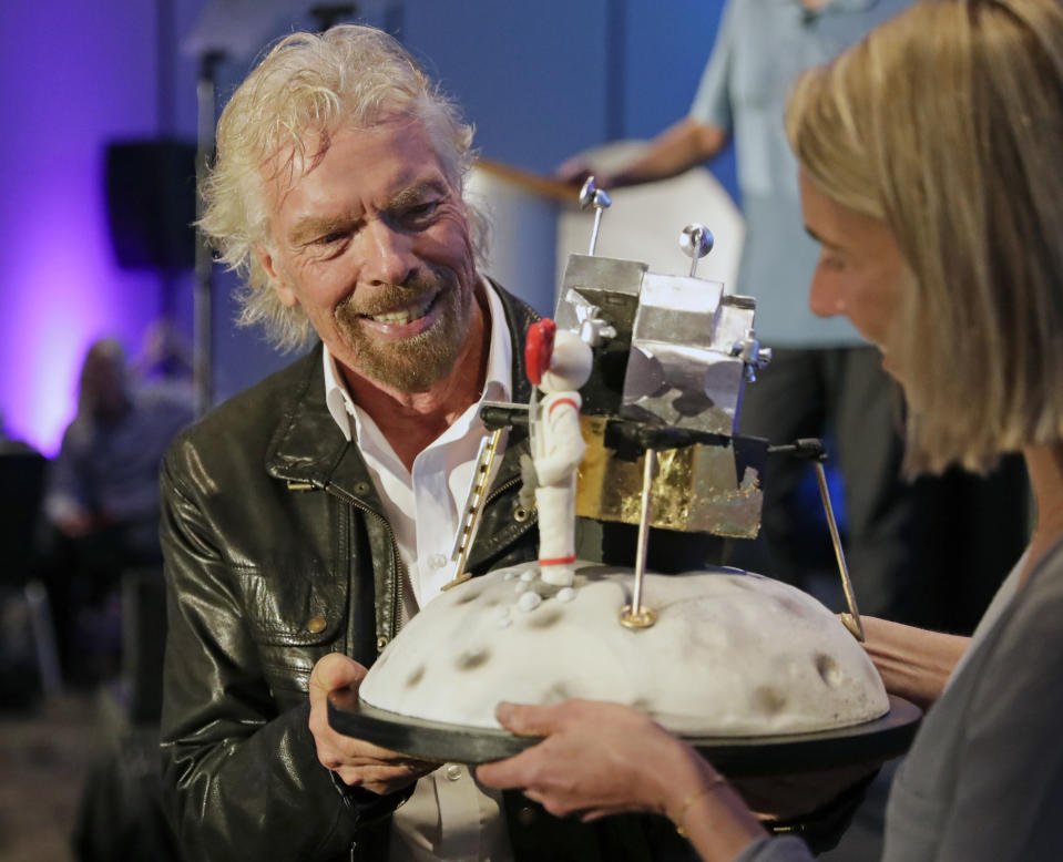 Richard Branson is presented with a space-themed cake during a luncheon attended by 100 Virgin Galactic ticket holders, to mark his 69th birthday and in recognition of the Apollo 11 moon landing anniversary at the Kennedy Space Center Visitor Complex, Thursday, July 18, 2019, in Cape Canaveral, Fla. (AP Photo/John Raoux)