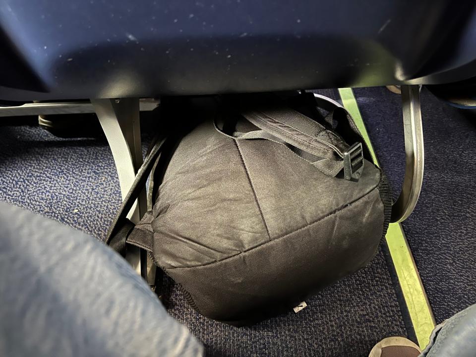 A backpack under a seat.