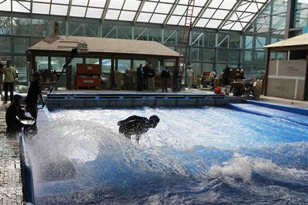 Todd Holland, former professional surfer on the world tour, tests the waves on a surfboard at the still under-construction Surf's Up indoor water and surf park in Nashua, New Hampshire November 15, 2013. REUTERS/Brian Snyder