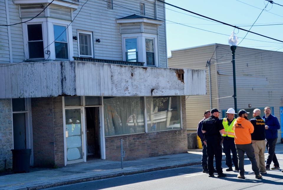 Hancock Town Manager Michael Faith, right, and other officials stand in front of 55 W. Main St. on Monday afternoon after search crews finished and did not find anyone inside the partially collapsed building. Washington County is condemning the building.