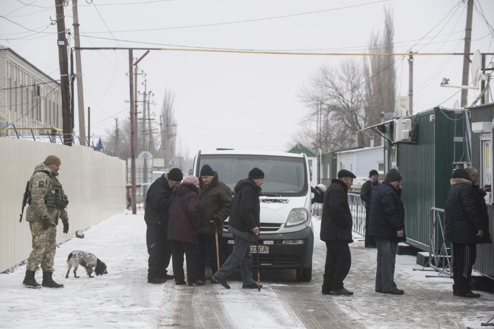People lineup to cross the border to Russia at the Ukrainian side of the Ukraine - Russia border in Milove town, eastern Ukraine, Sunday, Dec. 2, 2018. On a map, Chertkovo and Milove are one village, crossed by Friendship of Peoples Street which got its name under the Soviet Union, and on the streets on both places, people speak a mix of Russian and Ukrainian without turning choice of language into a political statement. (AP Photo/Evgeniy Maloletka)