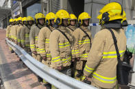 Firefighters gather near the site of a high-rise fire in Hong Kong, Friday, March 3, 2023. Hong Kong firefighters battled a blaze Friday that broke out overnight at a construction site in a popular shopping district and forced around people in nearby buildings to evacuate. (AP Photo)