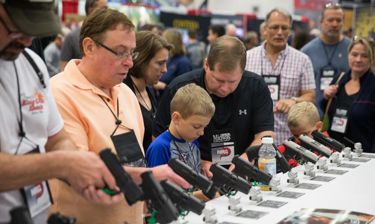 <span class="caption">NRA conventiongoers, like these at the gun group's 2018 big meeting, browse firearms exhibits.</span> <span class="attribution"><a class="link " href="https://www.gettyimages.com/detail/news-photo/people-browse-firearms-in-an-exhibit-hall-at-the-nras-news-photo/955072294" rel="nofollow noopener" target="_blank" data-ylk="slk:Loren Elliott/AFP via Getty Images;elm:context_link;itc:0;sec:content-canvas">Loren Elliott/AFP via Getty Images</a></span>