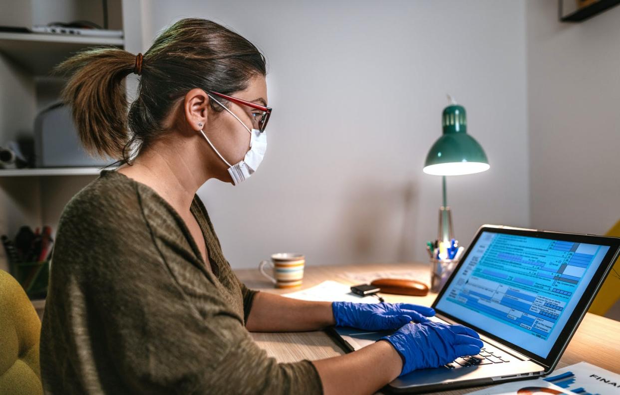 <span class="caption">Filing taxes during coronavirus times.</span> <span class="attribution"><a class="link " href="https://www.gettyimages.com/detail/photo/woman-filling-online-tax-form-wearing-face-mask-and-royalty-free-image/1215490527?adppopup=true" rel="nofollow noopener" target="_blank" data-ylk="slk:Drazen/ E+ via Getty Images;elm:context_link;itc:0;sec:content-canvas">Drazen/ E+ via Getty Images</a></span>