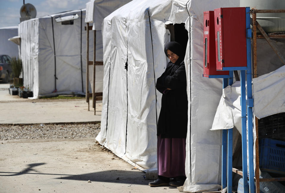 A Syrian displaced woman stands at the entrance of her tent at a refugee camp, in Bar Elias, in eastern Lebanon's Bekaa valley, Friday, March 5, 2021. Syria has been mired in civil war since 2011, after Syrians rose up against President Bashar Assad amid a wave of Arab Spring uprisings. Nearly ten years later, millions of displaced Syrians unlikely to return in the foreseeable future, even as they face deteriorating living conditions abroad. The Syrian conflict has resulted in the largest displacement crisis since World War II. (AP Photo/Hussein Malla)