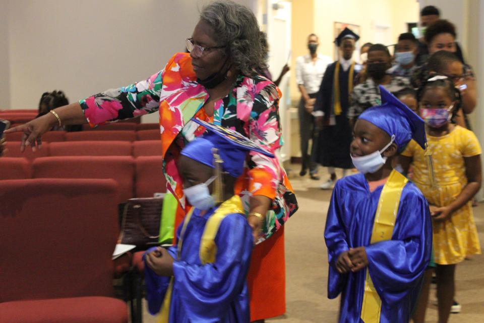 Gloria Simmons, left, director of Christian education at First Missionary Baptist Church, led a processional of young parishioners at the church who graduated from different levels of education this graduation season during a service Sunday celebrating National Children's Day.