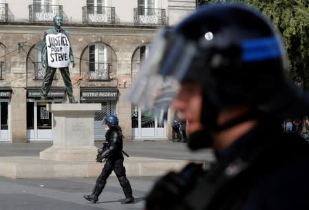 French gendarme walks in front of a banner reading : "Justice for Steve" during a demonstration on Act 44 (the 44th consecutive national protest on Saturday) of the yellow vests movement in Nantes