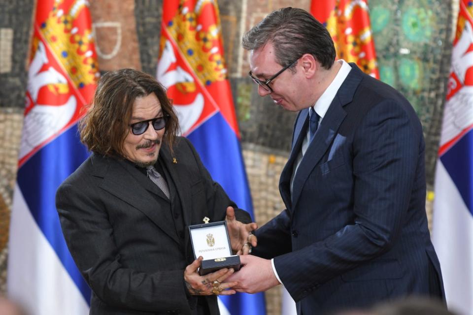 Depp receives the Gold Medal of Merit from Vucic (Getty Images)