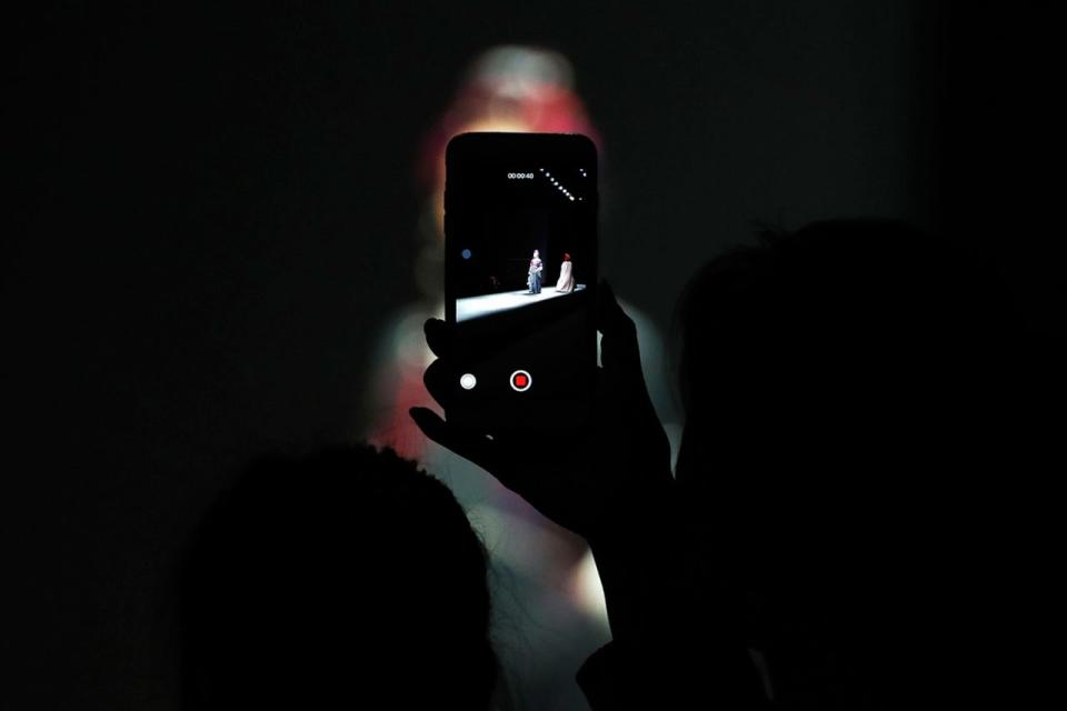 <p>Eine Zuschauerin filmt während der China Fashion Week in Beijing mit einem Smartphone die Modenschau von Aj-Namo aus Tibet. (Bild: Andy Wong/AP) </p>