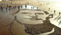 <p>A Grenadier Guardsman salutes the portrait of fallen soldier John Hardyman etched in the sand in Weston-super-Mare, Somerset. (SWNS) </p>