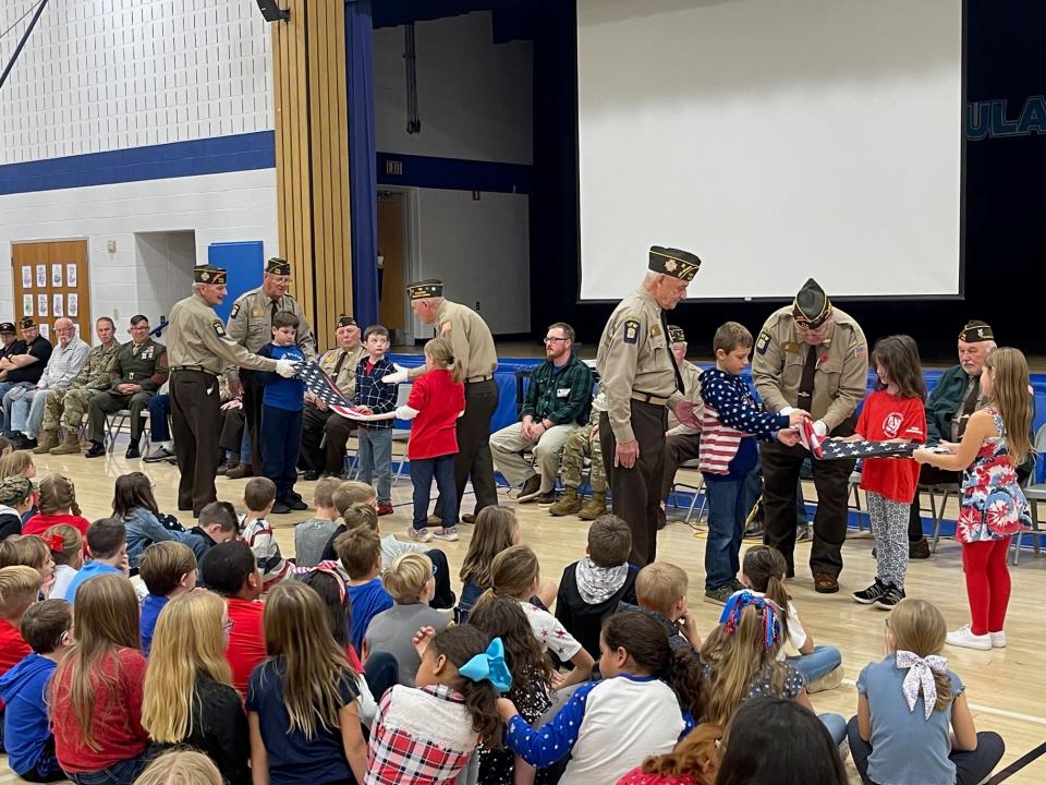 Members of Windber VFW Post No. 4795 teach the second graders at Windber Elementary how to correctly fold a U.S. flag. Pictured in the center left of the photo are, from left to right: Ralph Monotti, Harry Barnes and Lindsay Mihalko with students Chess Thomas, Grayson Hersh and Lexi Kachur; at center right are Rich Opett and Terry Phillips with students Gage Young, Hailee Neissner and Kinsley Miller.