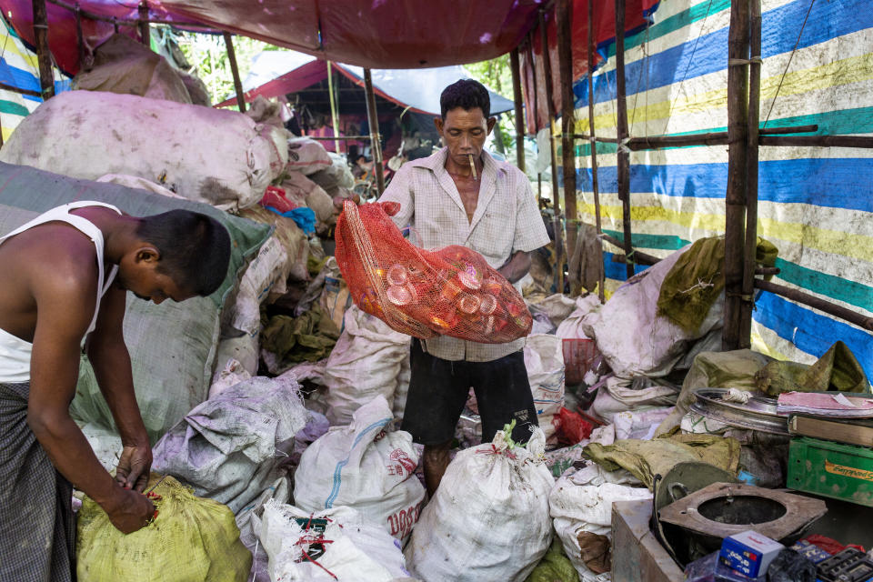 A man organizes materials at the recycle shop before sending them to the recycling factory. (Photo: Hkun Lat for HuffPost)