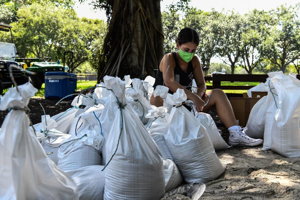 A woman prepares sand bags for distribution to the residents of Palmetto Bay near Miami, on July 31, 2020 as Floridians prepare for Hurricane Isaias. / Credit: CHANDAN KHANNA/AFP via Getty Images