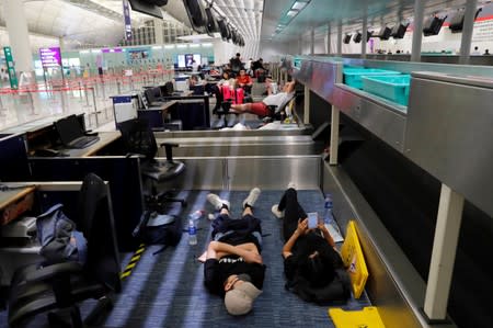 Anti-extradition bill protesters rest during a mass demonstration after a woman was shot in the eye, at Hong Kong International Airport