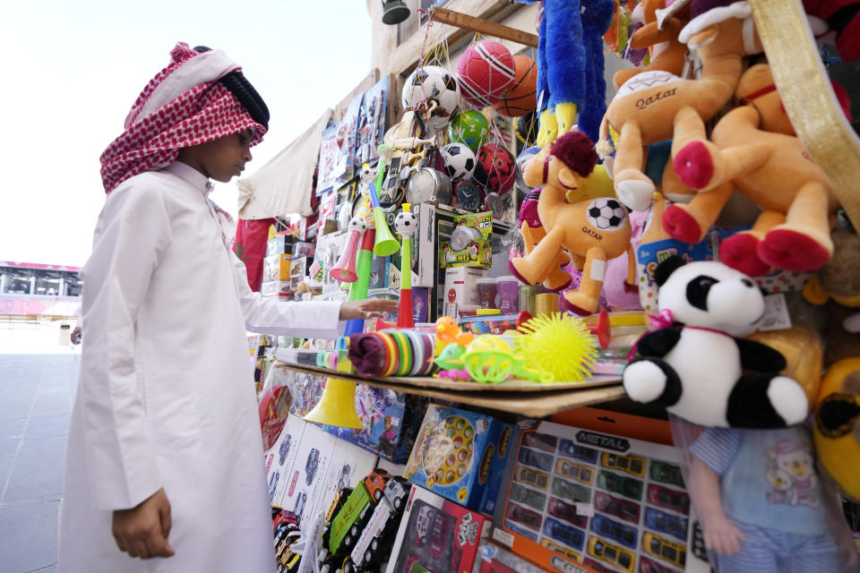 A child looks at the goods sold at a souvenir shop at the Souq Waqif Market in Doha, Qatar, Tuesday, Nov. 29, 2022. (AP Photo/Eugene Hoshiko)