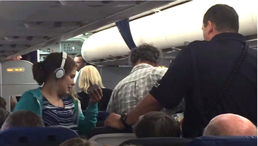 Police escort: Juliette and her family are removed from the plane. Photo: YouTube