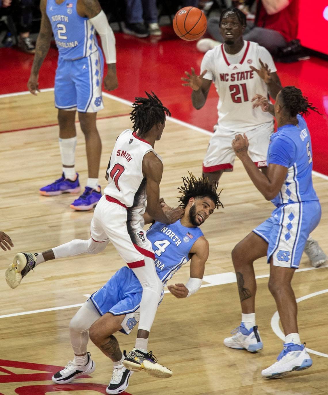 N.C. State’s Terquavion Smith (0) collies with North Carolina’s R.J. Davis (4) during the first half on Sunday, February 19, 2023 at PNC Arena in Raleigh, N.C. Davis was called for a blocking foul.