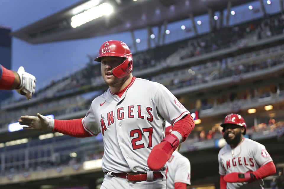 Los Angeles Angels' Mike Trout (27) and Luis Rengifo (2) are congratulated after scoring against the Minnesota Twins during the third inning of a baseball game Saturday, Sept. 24, 2022, in Minneapolis. (AP Photo/Andy Clayton-King)