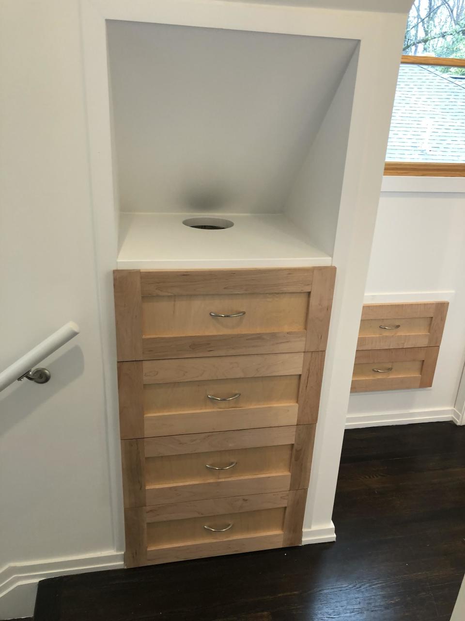 laundry chute hidden in the corner of a built-in in hallway