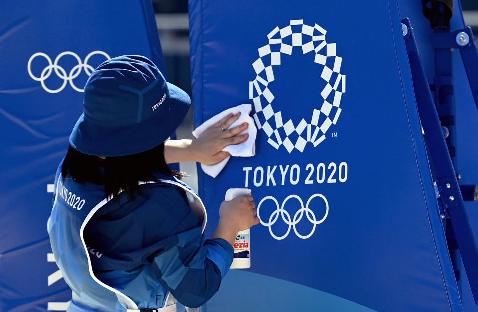 A worker sanitizes and cleans the Olympic beach volleyball court in between training sessions at Shiokaze Park in Tokyo. (ANGELA WEISS/AFP via Getty Images)