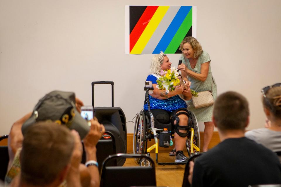 Melinda Preciado, left, receives a bouquet of flowers from volunteer Trish DeBaun after speaking at a disability awareness festival at Hilyard Community Center on July 15.
