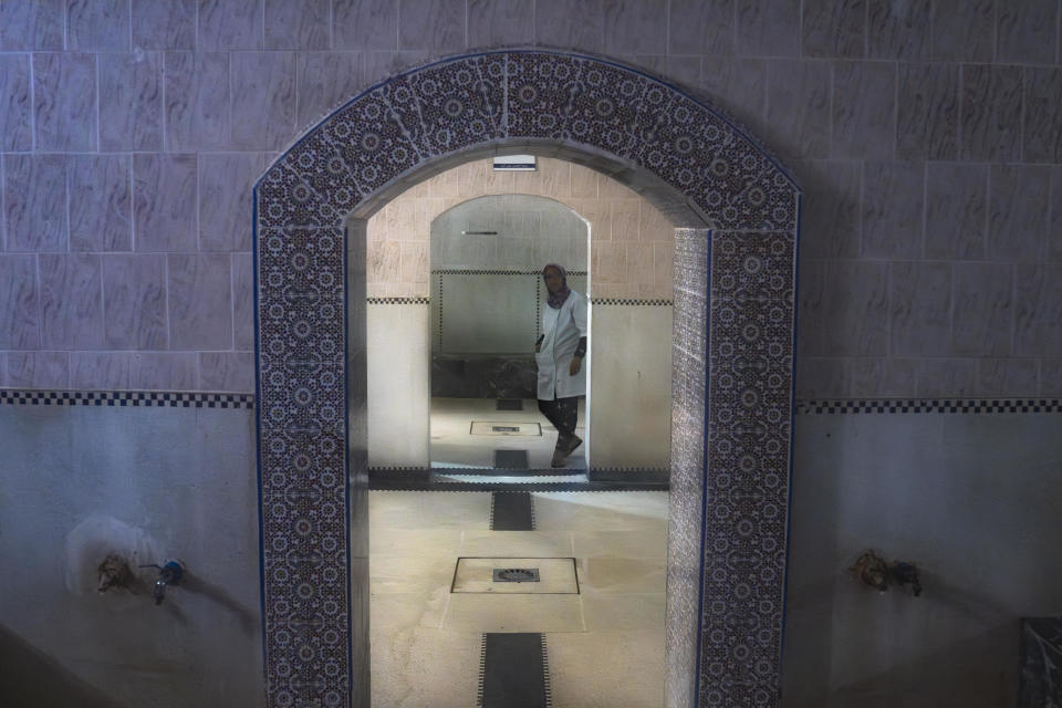 A worker walks inside an empty Moroccan traditional bath, known as hammam, in Rabat, Morocco, Monday, March 4, 2024. Climate change and a yearslong drought have forced Morocco's famous public baths to close a few days a week in an effort to save water. (AP Photo/Mosa'ab Elshamy)