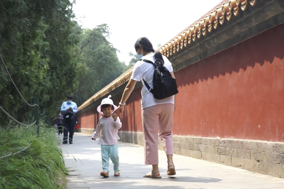 Mother of two, Yue Yan looks after one of her daughters at a park in Beijing on Thursday, May 20, 2021. Yue, 35, spends days looking after her 2-year-old and evenings helping her 10-year-old with homework. The ruling party is easing official limits on the number of children each couple can have, hoping to counter the rapid aging of Chinese society. But the number of births is falling. Couples are put off by costs, disruptions to jobs and the need to look after elderly parents. (AP Photo/Olivia Zhang)