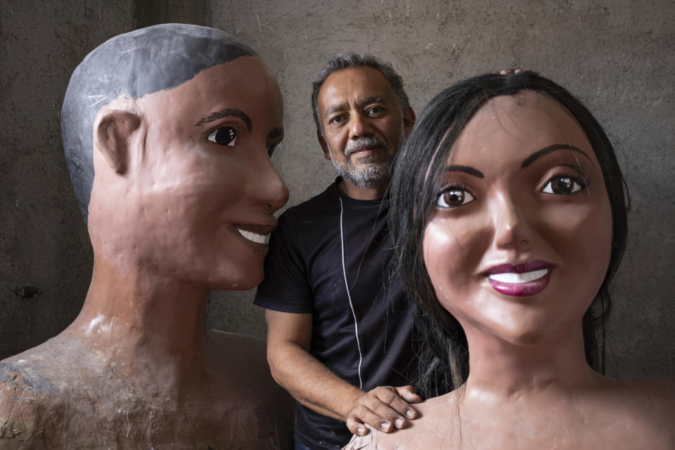 Tonatiuh Estrada, a Oaxacan artist, poses with his creations in Oaxaca, Mexico, Sunday, July 16, 2023. Estrada was asked to create dolls representing women from the eight regions of the state. The three-meter-tall figures are regularly used during “calendas,” as Oaxacans call processions held during Catholic festivities to honor their patrons or saints. (AP Photo/Maria Alferez)