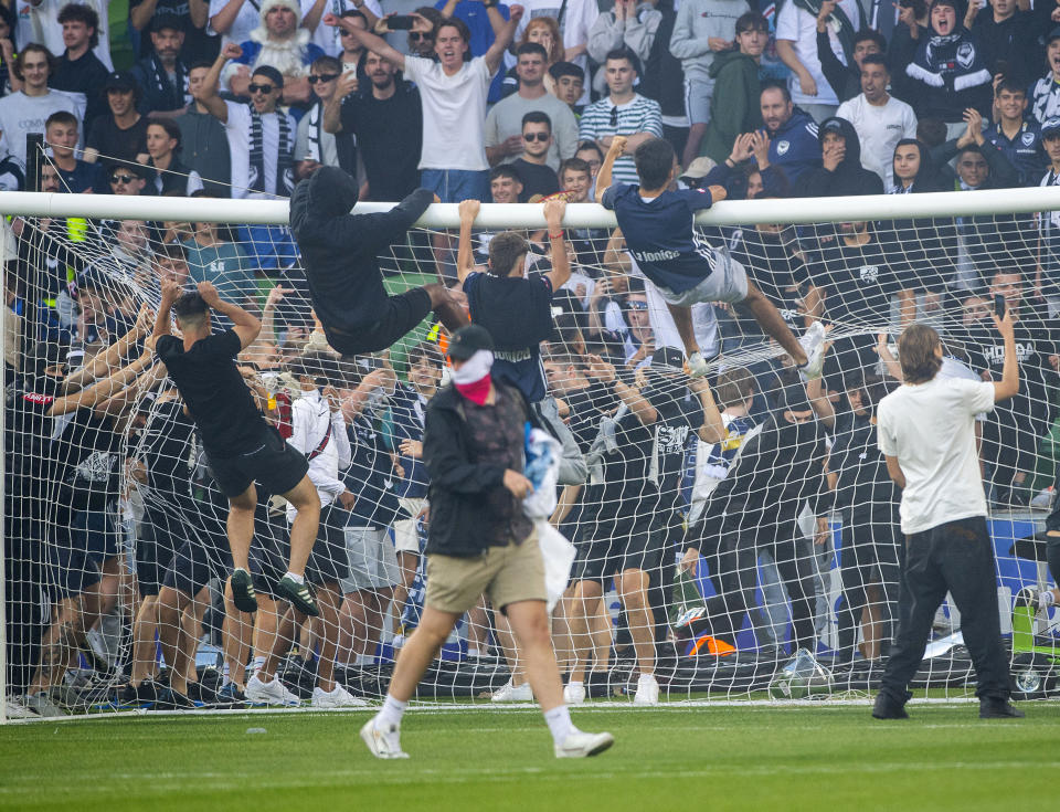 Melbourne Victory fans invade the pitch during the A-League men's soccer match between Melbourne City and the Melbourne Victory at AAMI Park in Melbourne, Australia Saturday, Dec. 17, 2022. The soccer match between rivals Melbourne City and Melbourne Victory was abandoned Saturday after fans invaded the field and attacked City goalkeeper Tom Glover.(Will Murray/AAP Image via AP)