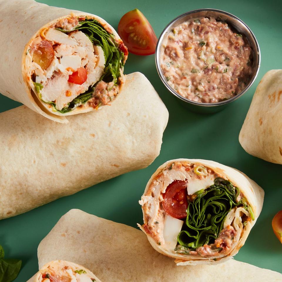 whole wheat wrap spread with parmesan herb mayonnaise and wrapped around chopped rotisserie chicken, creamy fresh mozzarella, spinach, and cherry tomatoes